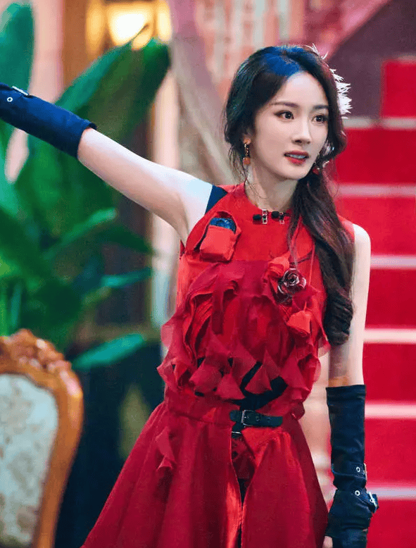 杨幂一袭红色立体花瓣裙，头戴羽毛配饰灵动似少女