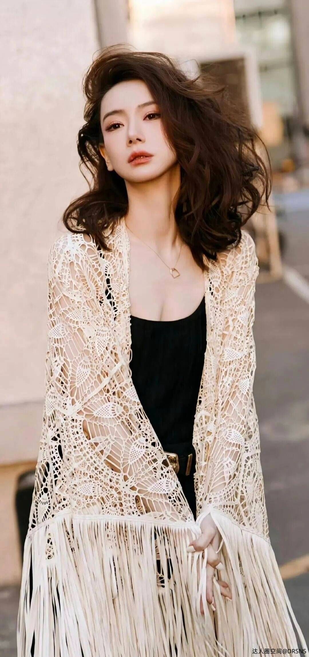 戚薇镂空针织衫搭配黑色吊带,她随性街头感的流动美学 戚薇镂空针织衫搭配黑色吊带,她随性街头感的流动美学